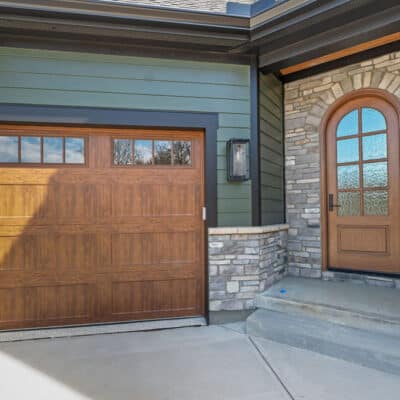 Green House Siding, Stone Cedar and black accents on house. Arched front door arched friends door