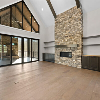 Great Room With Stone Fireplace and Access To Covered Screened-In Porch Built-ins