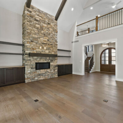 Vaulted Ceiling in Great Room With Stone Fireplace and loft with balcony