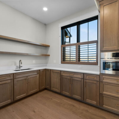 Hidden Pantry With Open and Closed Shelving Wood Stained Cabinetry