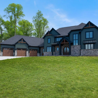 Two Story Custom Home Cleaves Stone Dark Green Siding Stone and Cedar Accents