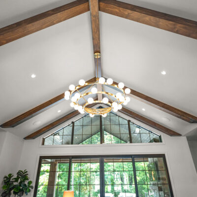 Vaulted Ceiling With Beams and Stone Fireplace In Great Room Statement Chandelier