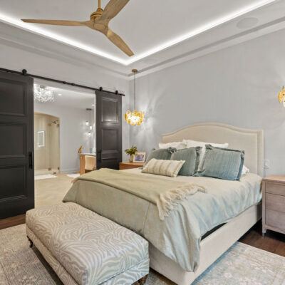 Primary Bedroom Tray Ceiling With Lighting and Barn Door To Bathroom
