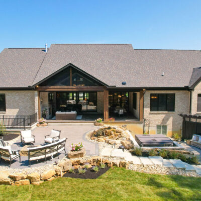 Rear Exterior with Covered Porch Firepit Area Stone Stairs to Hot Tub and Curved Stone Bench