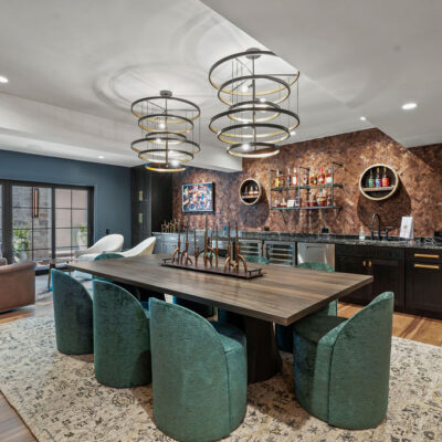 Elegant Bourbon Room With Large Tasting Table and Bar With Oak Cabinetry Stained Black Double Chandeliers