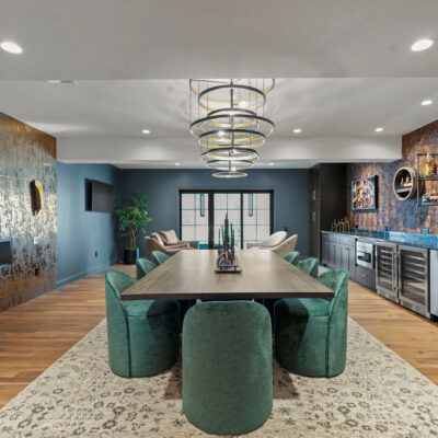 Elegant Bourbon Room With Large Tasting Table and Bar With Oak Cabinetry Stained Black Double Chandeliers and Two Sided Fireplace