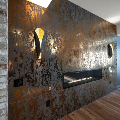 Two Sided Fireplace In Bourbon Room Iron and Copper Tile With sconces