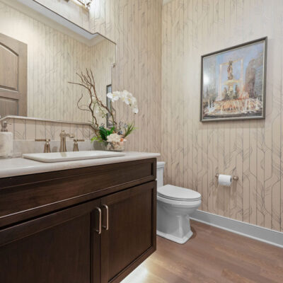 Powder Room With Stained Cabinetry Vanity and Wallpaper