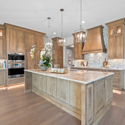 Paneled Refrigerator and Sub Zero Appliances With Custom Wood Stained Hood