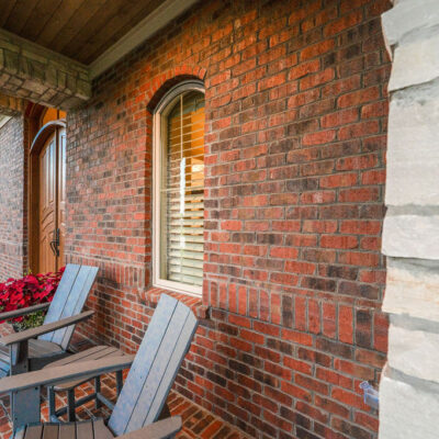 Covered Front Porch With Brick and Stone and Wood Stained Ceiling