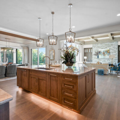Stained Custom Cabinetry In Kitchen With Quartzite Countertop Open To Great Room and Dining Area