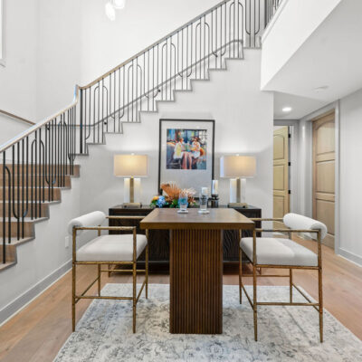 Open Staircase To Lower Level With Statement Chandelier and Window