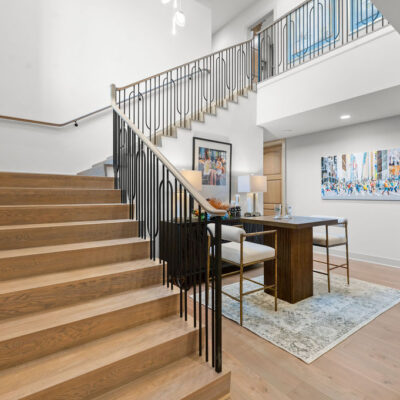 Open Staircase With Statement Chandelier to Lower Level