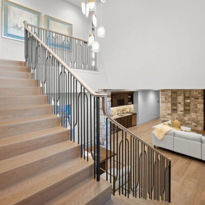 Open Staircase To Lower Level With Statement Chandelier