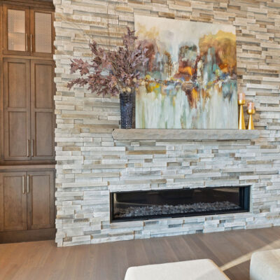 Stone Linear Fireplace In Great Room With Dark Stained Built-Ins With Metal Mesh
