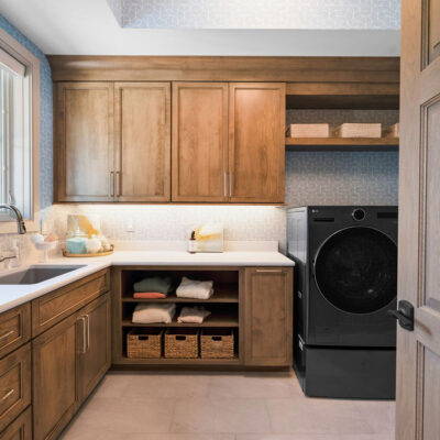 Laundry With Window and Closed and Open Custom Cabinetry, Sink and Washer and Dryer on Pedestal