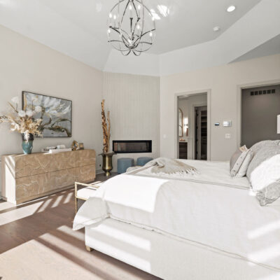 Octagon Shaped Primary Bedroom With Large Windows With Transom Above and Two Sided Fireplace Between Bedroom and Bathroom