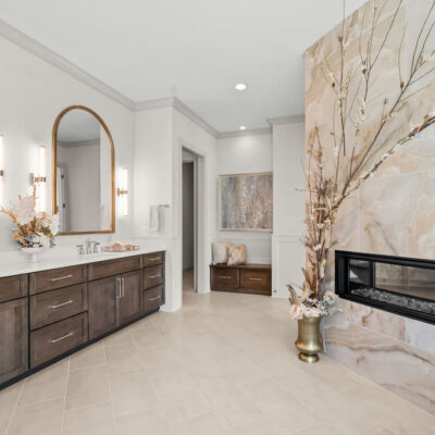 Primary Bathroom With Double Vanity and Free Standing Tub, Two Sided Fireplace With Oversized Tile and Bench
