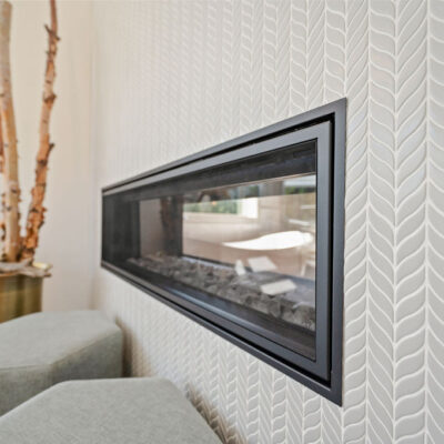 Two Sided Fireplace Between Primary Bedroom and Bathroom With Tile Wall