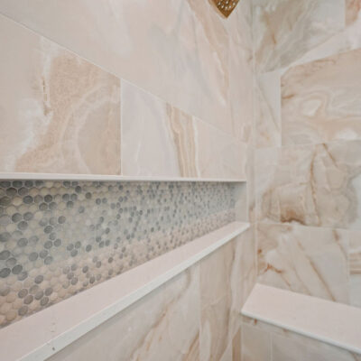 Oversized Tile and Niche In Primary Bathroom With Bench