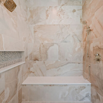 Oversized Tile and Niche In Primary Bathroom With Bench