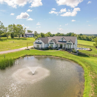 Modern Farmhouse with Gables, Siding, Stone, Metal Roof and Pond
