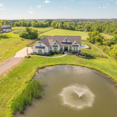 Modern Farmhouse with Gables, Siding, Stone, Metal Roof and Pond