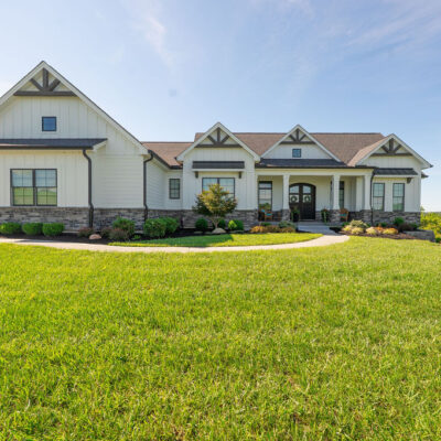 Modern Farmhouse with Gables, Siding, Stone, Metal Roof and Pond