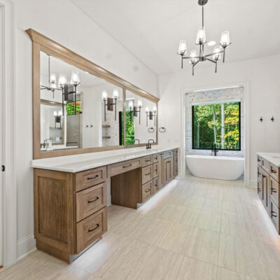 Luxury primary bathroom vanity with custom cabinetry, quartz countertops, expansive mirror, and makeup area at The Vandoren custom home in Liberty Township, Ohio.